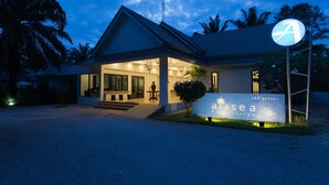 Une villa moderne dotée d’un hall d’entrée bien éclairé, d’un escalier apparent et d’une enseigne portant le nom « Aisea Villas ».