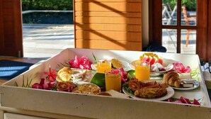 Un buffet de petit-déjeuner proposant une variété d’aliments, avec un écran de télévision en arrière-plan.