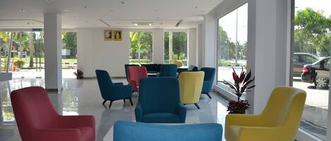 A modern waiting area with colorful chairs and large windows offering a view of the outdoors.