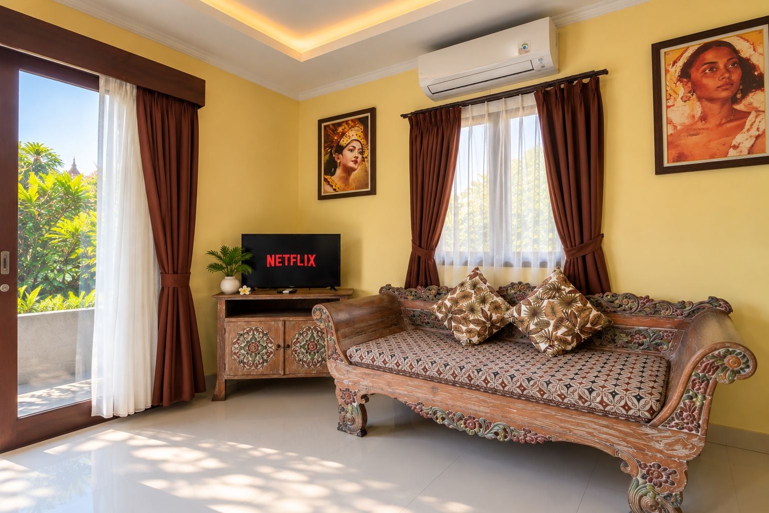 A living room with a sofa, a television displaying 'NETFLIX,' and a wall-mounted air conditioner.