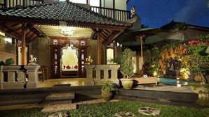 Un edificio tradicional japonés con tejado de tejas, vigas de madera y entrada de piedra.