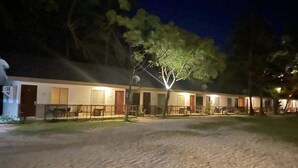 A row of single-story buildings with a sandy ground, likely a hotel or resort. - Anaya Beach Resort (Bantayan)