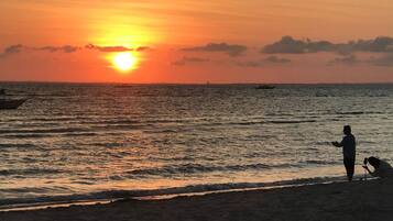 On the beach, white sand, sun loungers, beach umbrellas