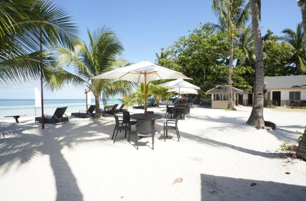 A beachside area with lounge chairs, umbrellas, and a building.