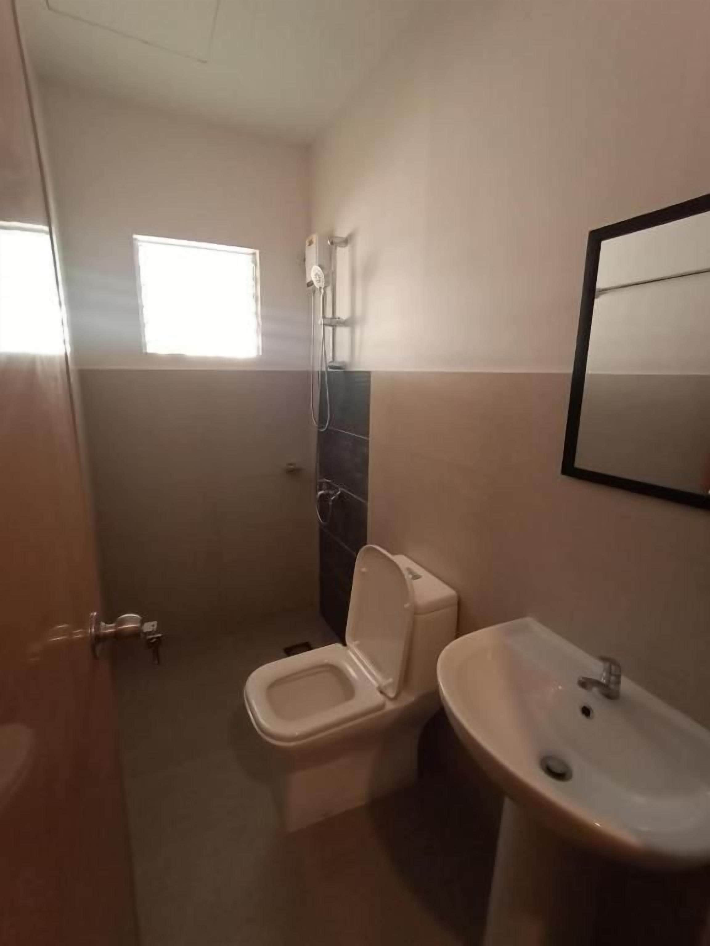 A bathroom with a toilet, sink, and shower.