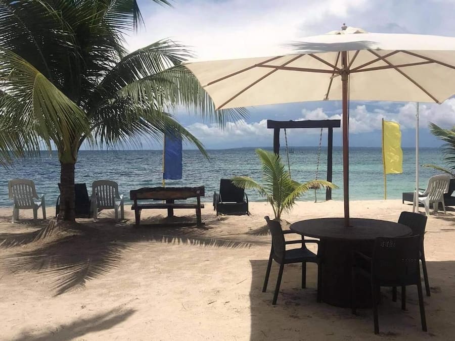 Na praia, areia branca, espreguiçadeiras, guarda-sóis