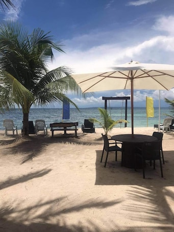 On the beach, white sand, sun loungers, beach umbrellas
