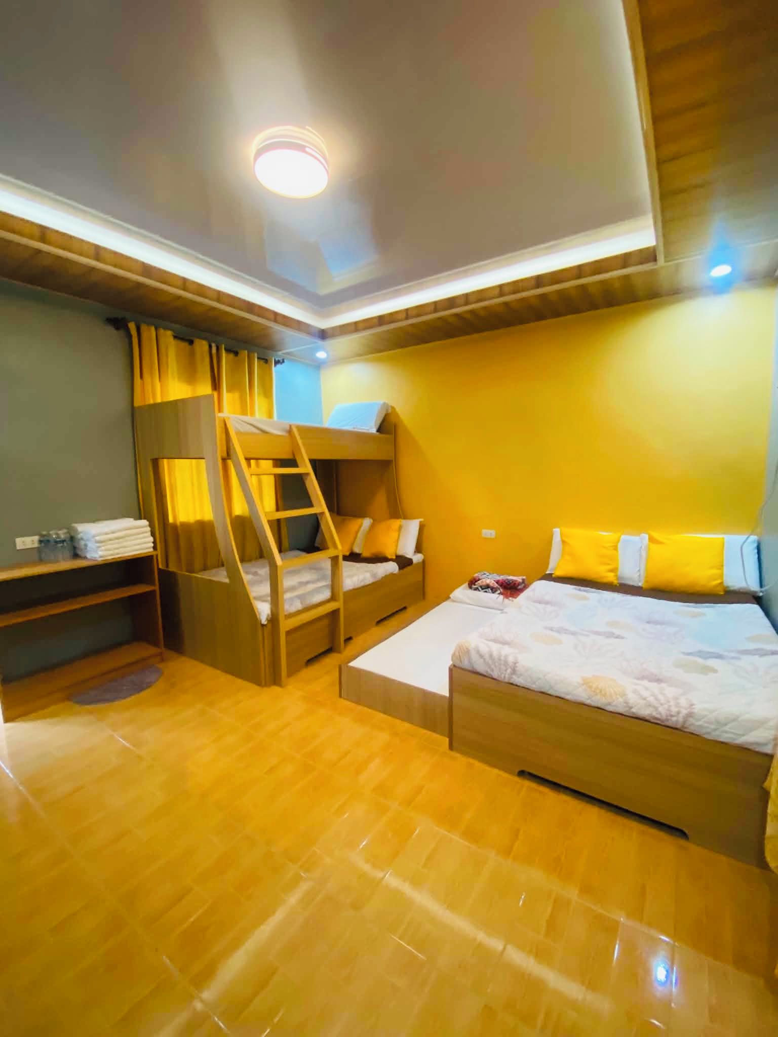 A room with bunk beds, a desk, and a bed with pillows.