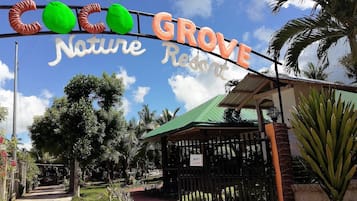 Een bordje voor Grove Nature Resort, met een pad dat naar een hek leidt.