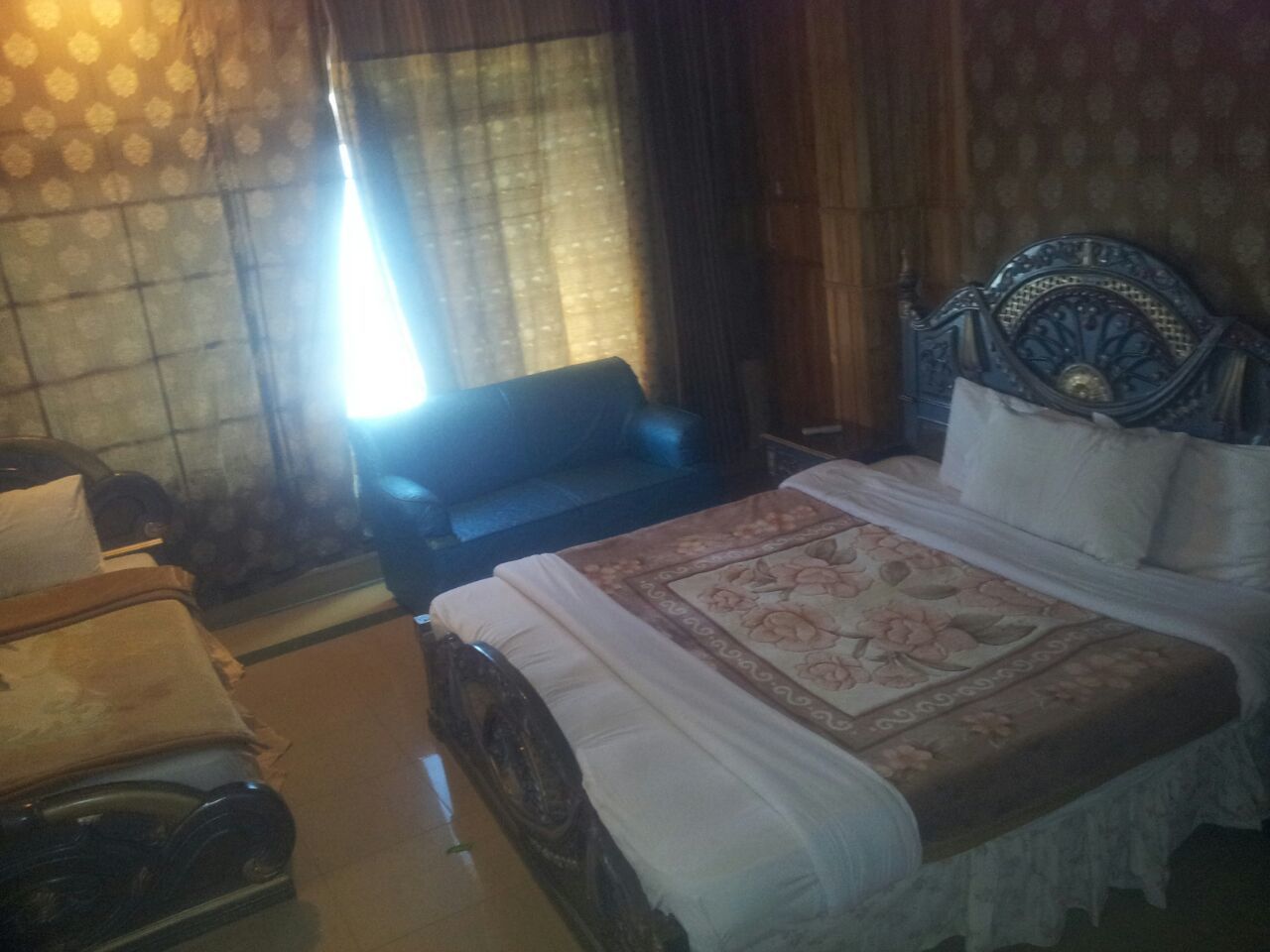 A bedroom with a large bed, a chair, and a desk.