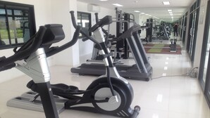 A gym with stationary bikes, treadmills, and weight machines. - Ratchaporn Place (Kathu)
