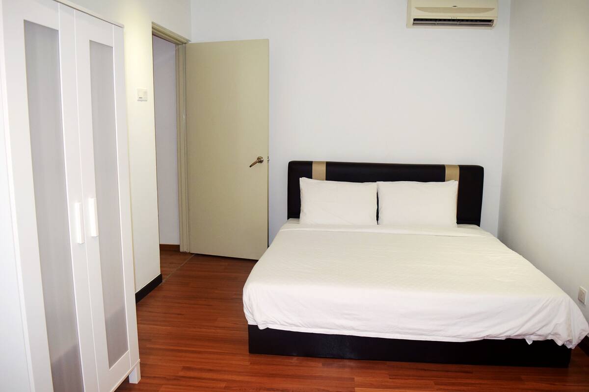 Un dormitorio con una cama, un armario y una puerta.