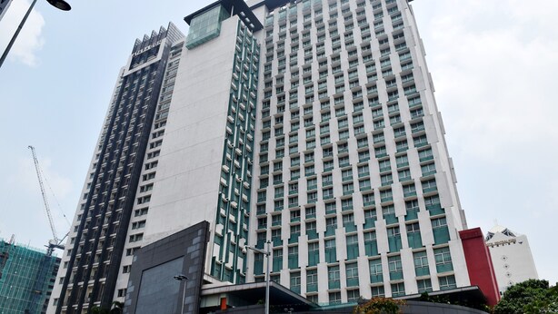 Un edificio de hotel alto con varios pisos y un letrero llamativo en la parte superior.