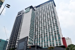 Un edificio de hotel alto con varios pisos y un letrero llamativo en la parte superior.