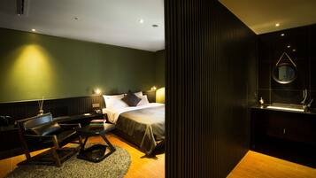 Une chambre d’hôtel moderne équipée d’un lit, d’un bureau, d’une chaise et d’une salle de bain avec un miroir.