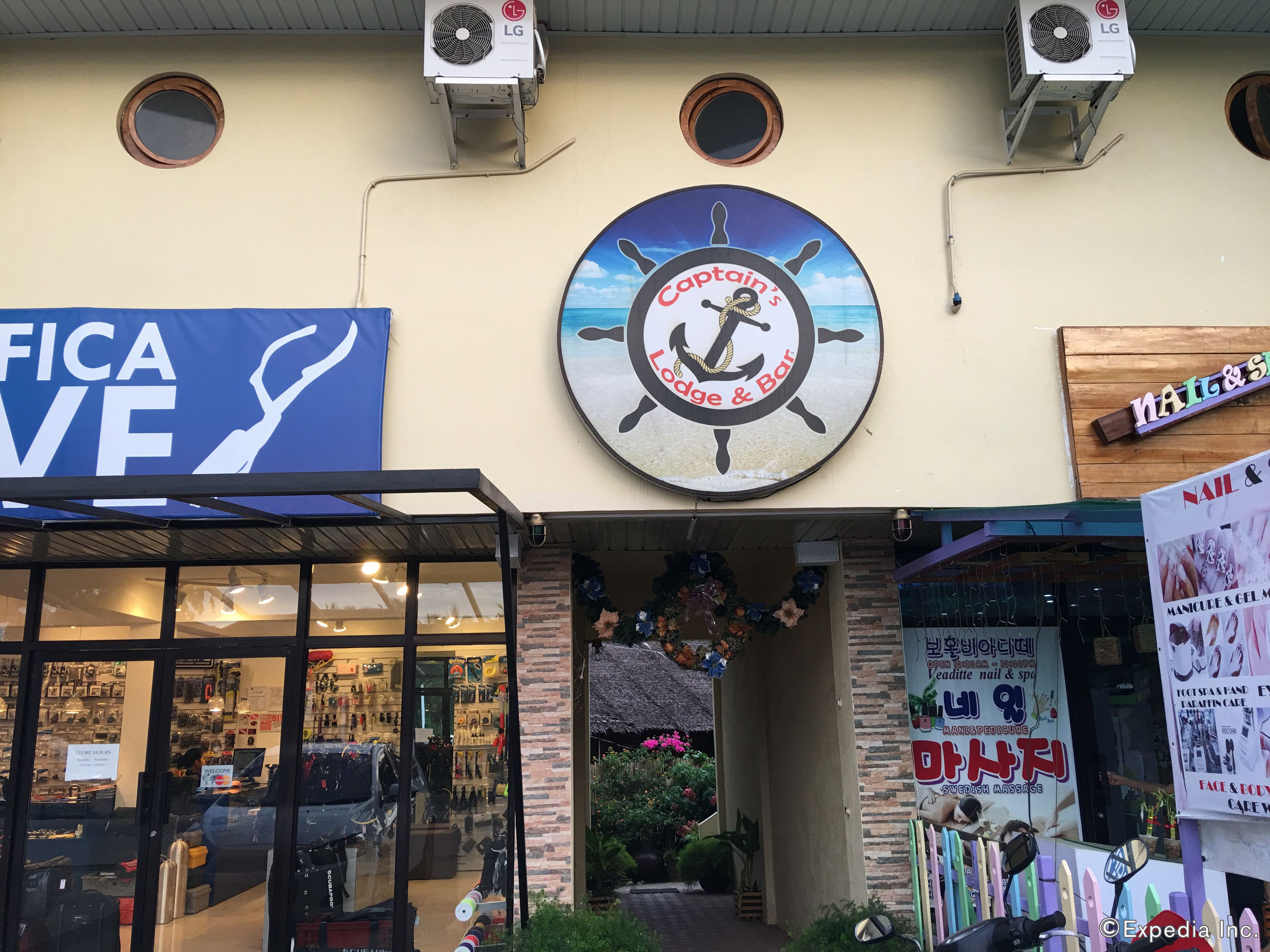A storefront with a sign for 'Captain's Lodge & Bar' and a 'Nail & Spa' sign.