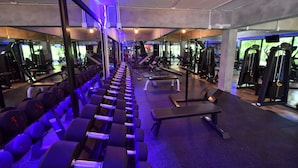 A gym with rows of dumbbells, benches, and various exercise machines. - The Touch Green Naiyang Hotel & Fitness (Sa Khu)