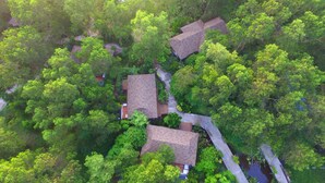 An aerial view of a residential area with three houses surrounded by dense greenery. - The Touch Green Naiyang Hotel & Fitness (Sa Khu)