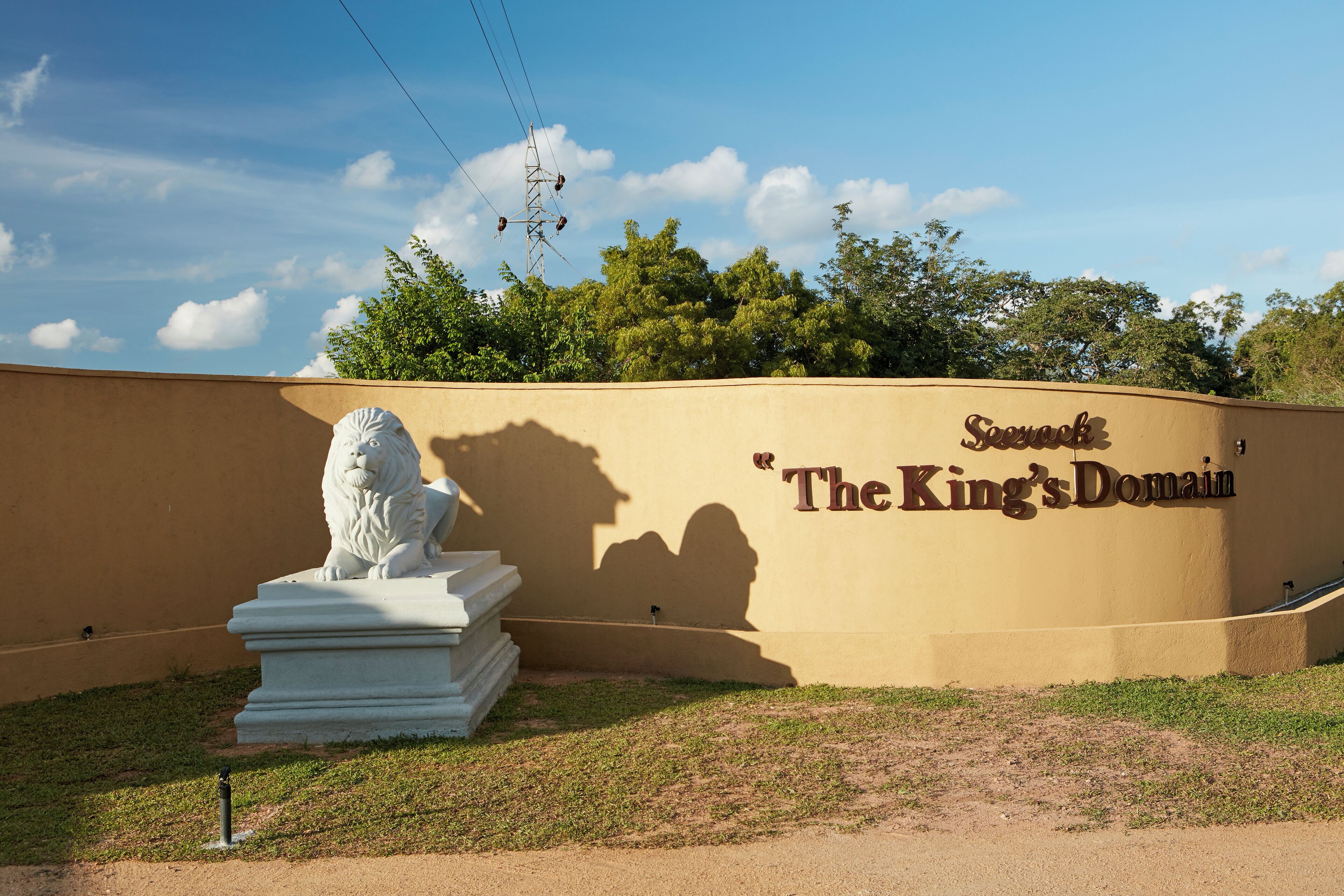 A wall with "Sequoia The King's Domain" text and a lion statue.