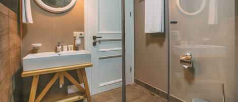 A modern bathroom with a wooden vanity, a glass shower enclosure, and a white toilet.