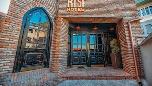 A brick building with a large arched window and a sign that reads "KSI HOTEL". - Kisi Boutique Hotel (Tbilisi)
