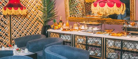 Een restaurant met een lange toonbank, blauwe gestoffeerde stoelen en een grote spiegel.