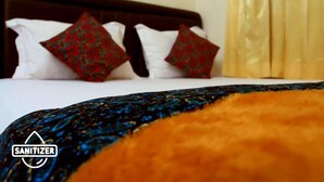 A hotel room with a bed, pillows, and a blanket. - Unique Guesthouse (Bandung)