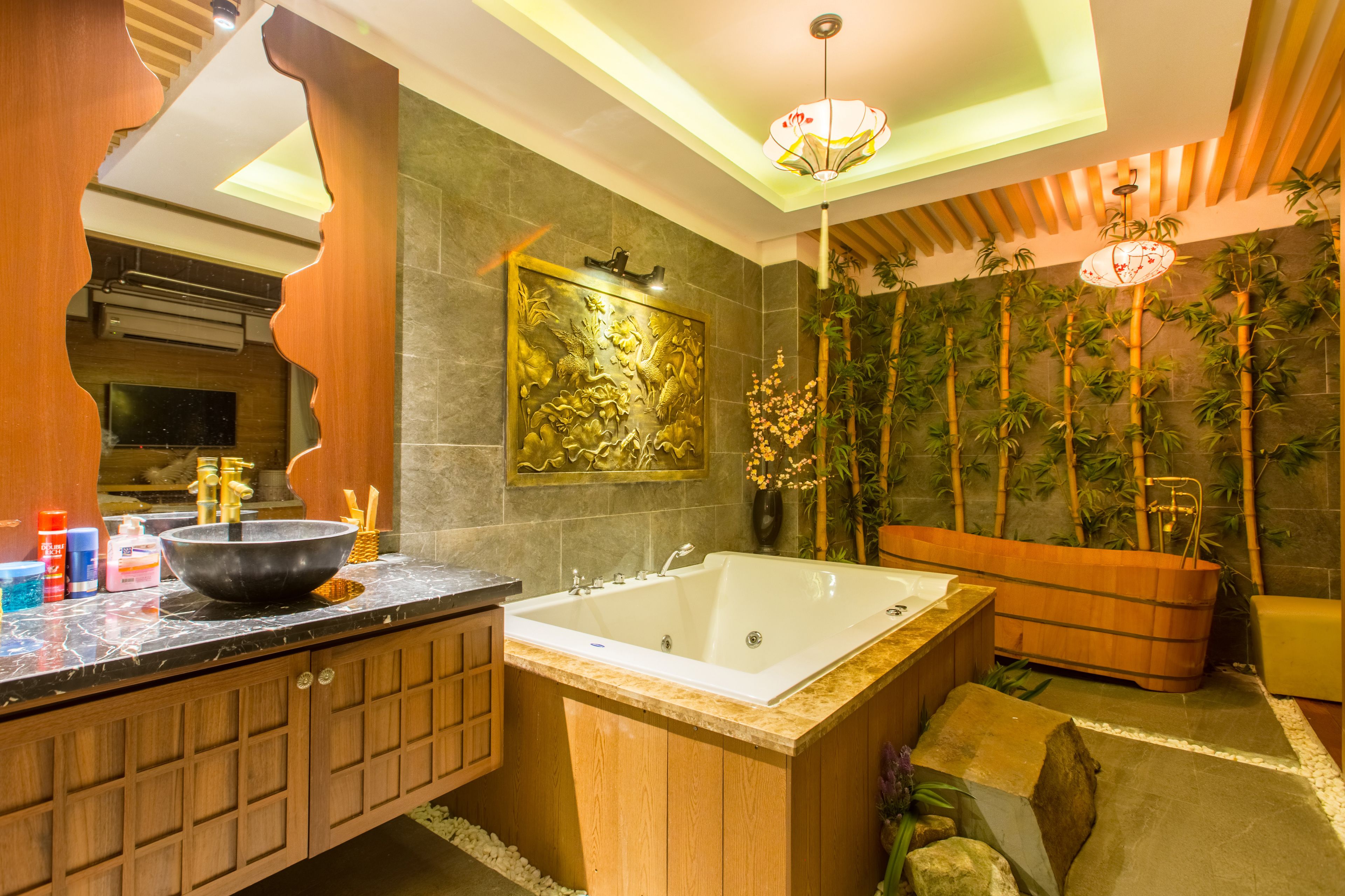 A modern bathroom with a large bathtub, wooden vanity, and a decorative wall with bamboo plants.