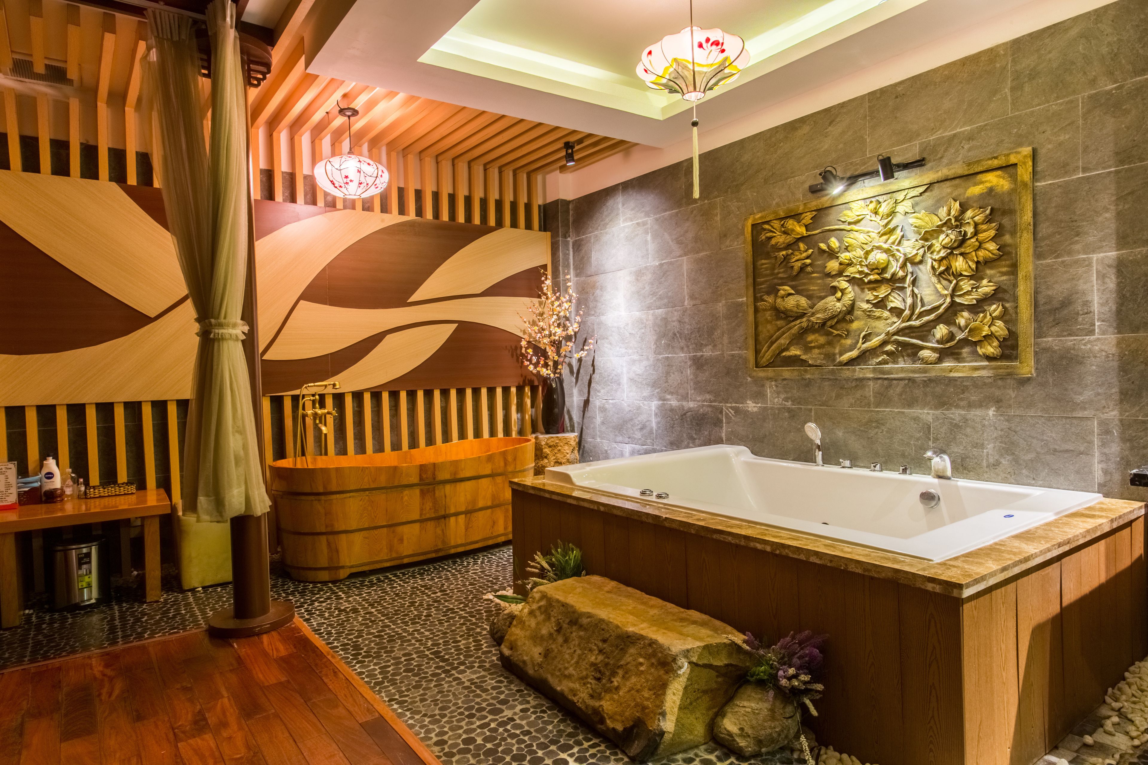 Un baño moderno con una bañera grande, detalles de madera, una pared de piedra y un mural decorativo.