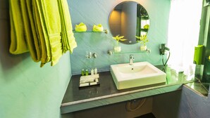 Une salle de bain avec un lavabo blanc, un miroir et un porte-serviettes.