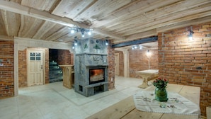 Um quarto aconchegante com lareira de pedra, vigas de madeira e paredes de tijolo.