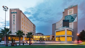 Um hotel com design moderno, com uma placa em destaque e uma entrada bem iluminada.