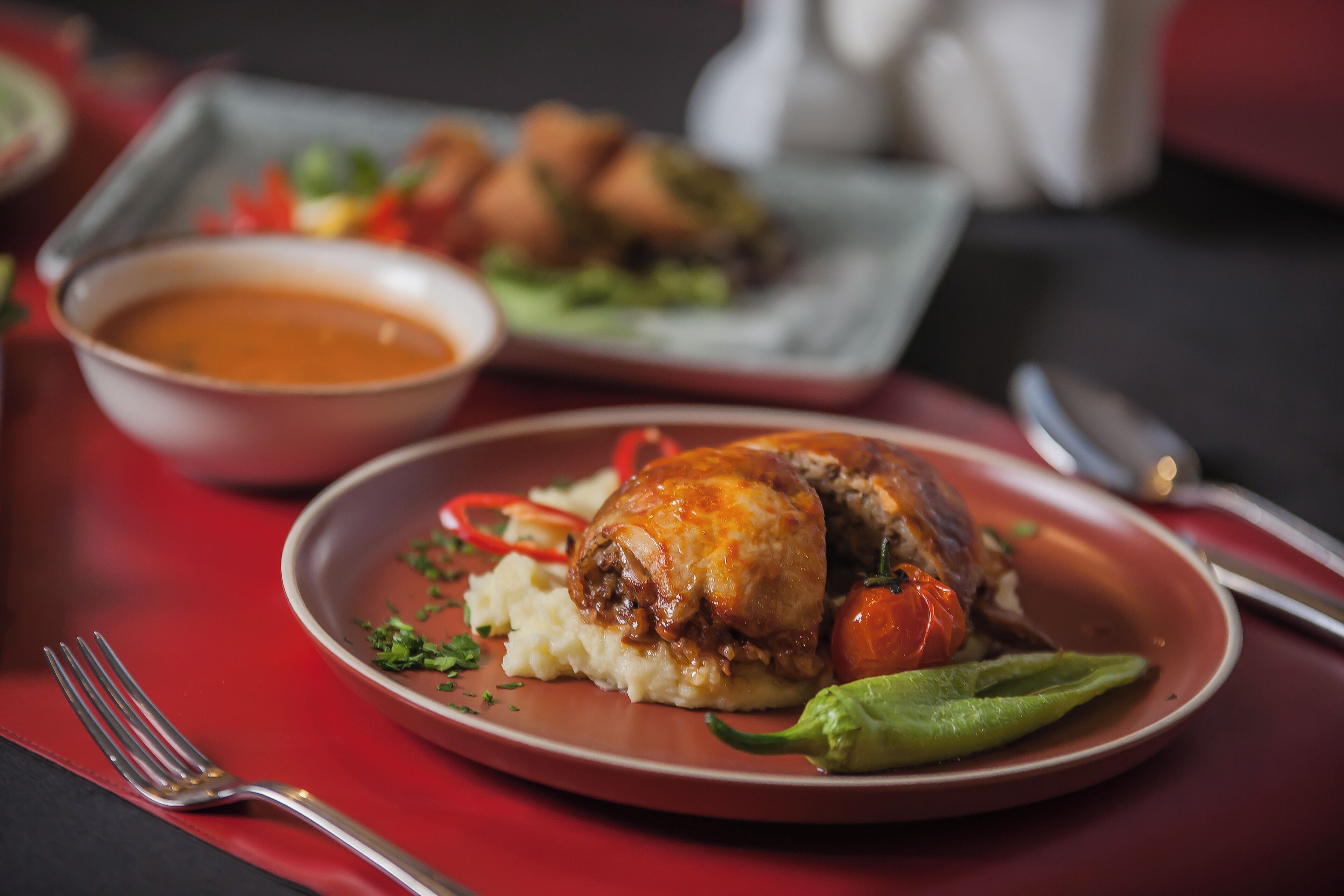 A plate of food with mashed potatoes, a roasted chicken, and vegetables.