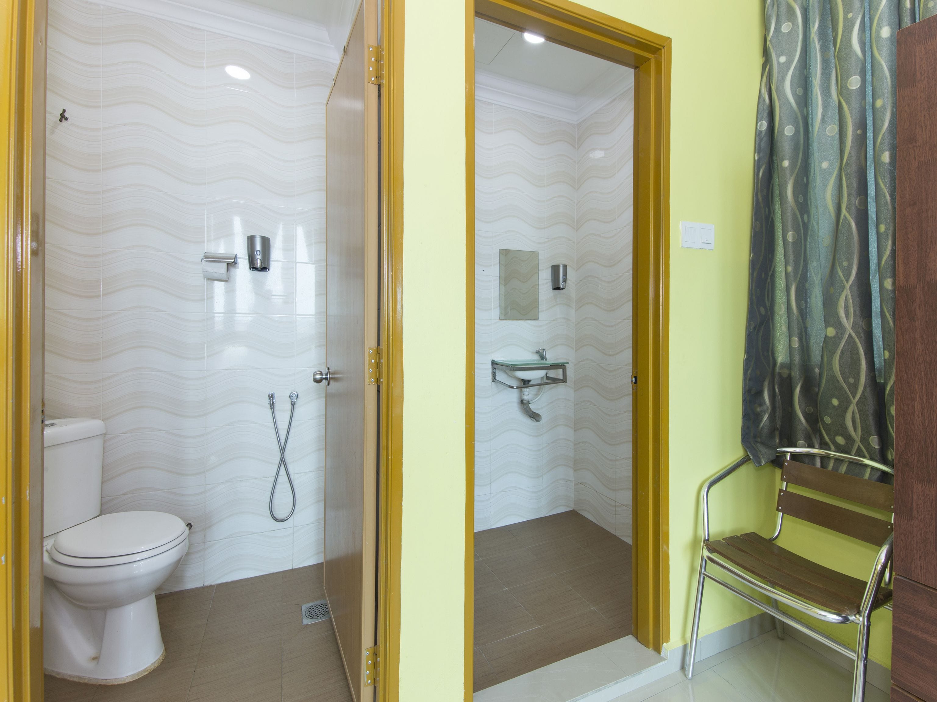 A bathroom with a toilet, shower, and sink.