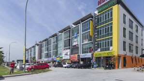 Un hôtel moderne à plusieurs étages, doté de grandes fenêtres et d’une enseigne bien visible indiquant « SAUJANA CITY HOTEL ».