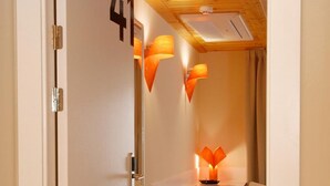 A hotel room with a wooden ceiling, a desk with a lamp, and a chair. - Hostal riMboMbin (Burgos)