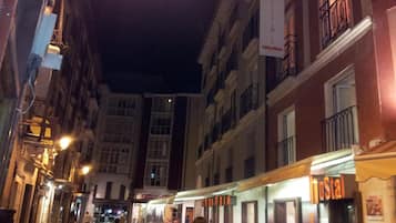 A narrow street lined with buildings, including a hostel with a sign.