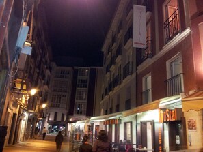 A narrow street lined with buildings, including a hostel with a sign.
