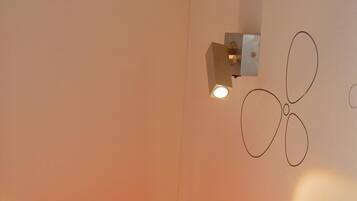 A modern lamp with a unique design on a bedside table in a hotel room.