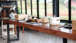 A kitchen counter with various cooking utensils, a slow cooker, and a wooden box.
