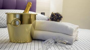 A bed with a gold bucket, a pair of glasses, and a bouquet of dried flowers.
