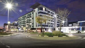 A multi-story hotel with a modern design, featuring a rooftop terrace and a landscaped courtyard.