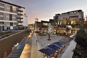 Un hotel moderno con varios pisos, espacios al aire libre y un patio bien iluminado.
