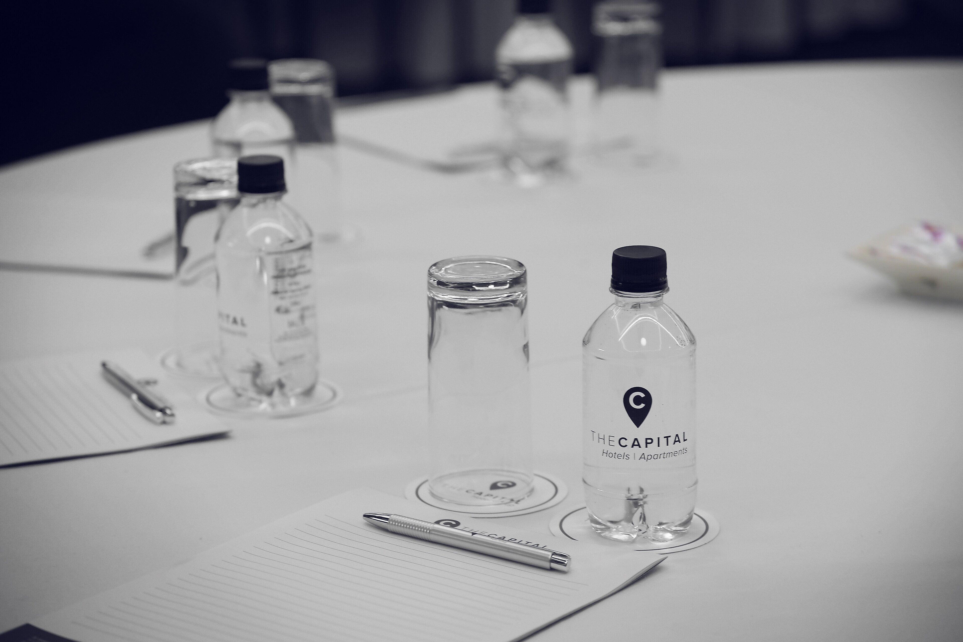 A conference table with water bottles, a pen, and documents.