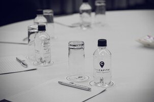 A conference table with water bottles, a pen, and documents.