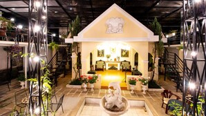 A lobby with a central seating area, a staircase, and potted plants. - Le Petit Paris Hotel Dalat (Cam Ly - Da Lat)