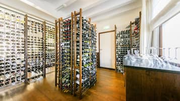 A wine cellar with multiple racks of wine bottles and glasses.