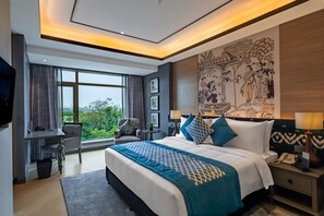 A modern hotel room with a large bed, a desk, and a view of the city. - Fortune Park Sishmo, Bhubaneswar - Member ITC Hotels' Group (Bhubaneshwar)