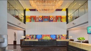 A lobby with a chandelier, a reception desk, and a colorful mural on the wall. - Fortune Park Sishmo, Bhubaneswar - Member ITC Hotels' Group (Bhubaneshwar)