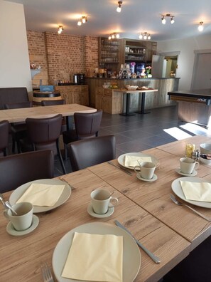 A restaurant with a brick wall, wooden tables, and chairs. - B&B de Oude Winning (Riemst)